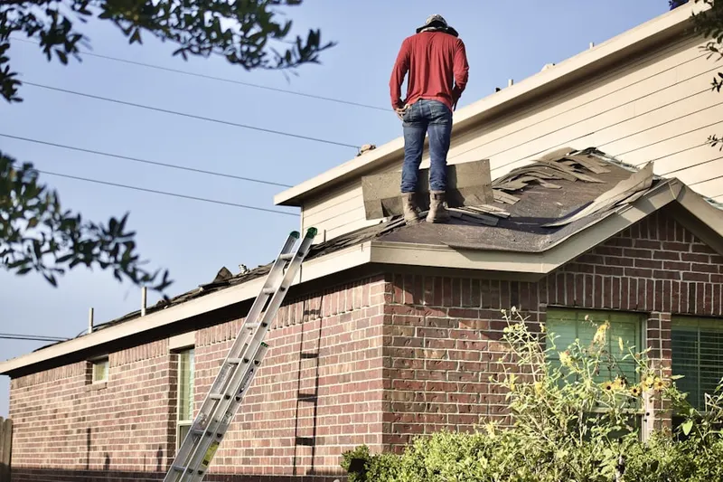 Professional roofer working on a residential roof in LeDroit Park